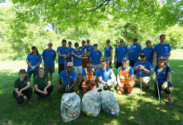 A group from 407 ETR clean up green space as part of One Big Day of Volunteering, on a sunny day.